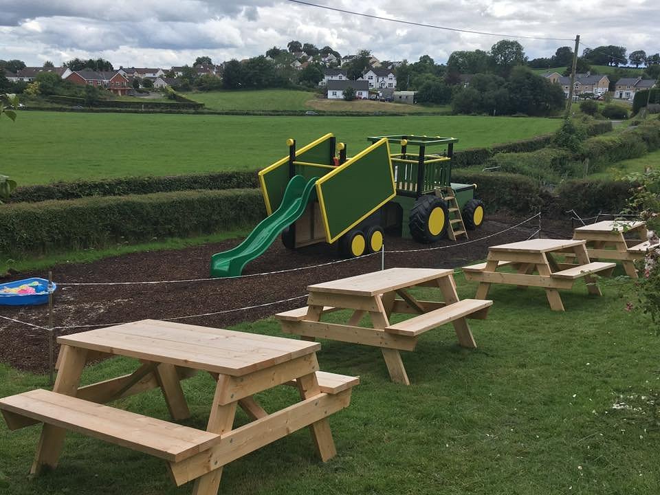 Fun farm outdoor setting with picnic table and green tractor slide prefect for birthday party ideas in Enniskillen